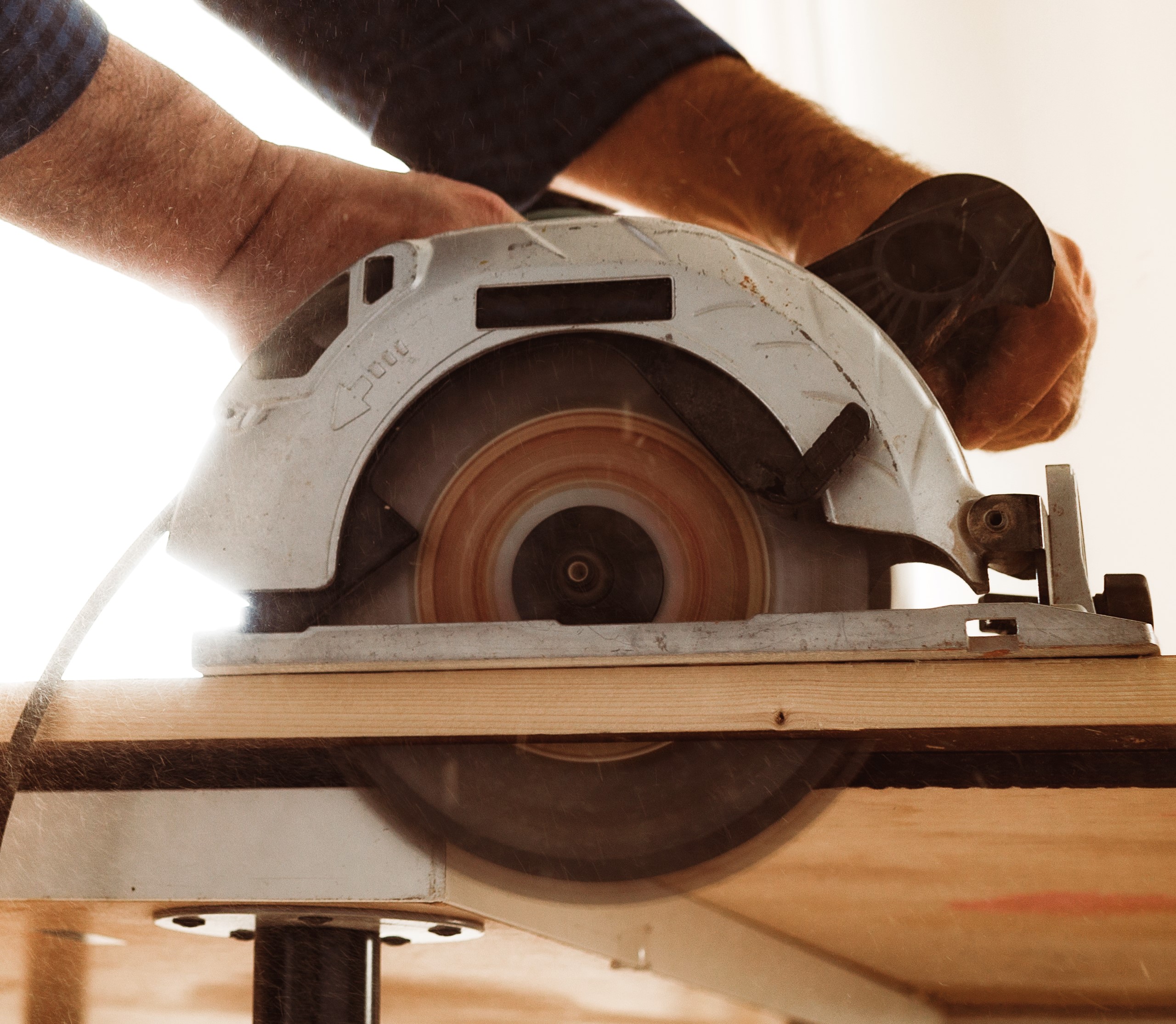 carpenter-hands-cutting-wood-with-electrical-saw carpenter-hands-cutting-wood-with-electrical-saw